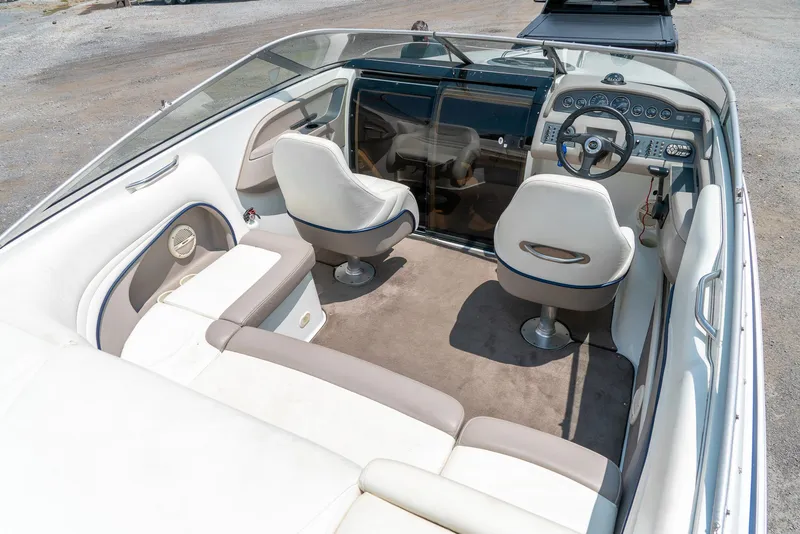 Slide: The Image of 2001 Cobalt 227 Cuddy boat interior with white seating and steering console. - 11