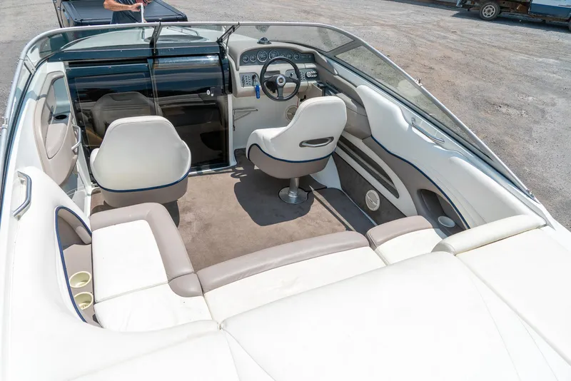Slide: The Image of 2001 Cobalt 227 Cuddy boat interior with white seating and steering wheel. - 12