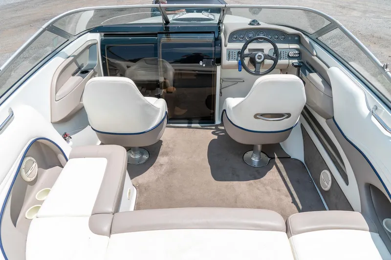 Slide: The Image of Interior of 2001 Cobalt 227 Cuddy boat with white seating and steering wheel. - 13