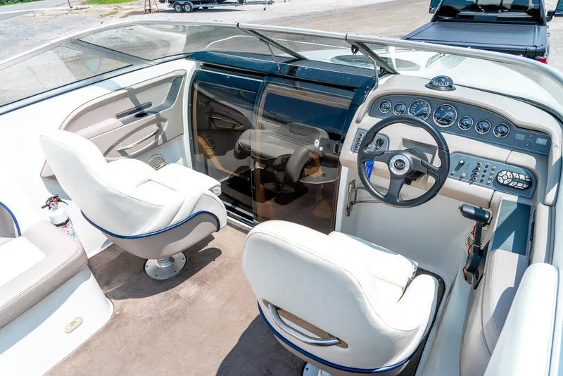 Slide: The Image of 2001 Cobalt 227 Cuddy boat interior with steering wheel, dashboard, and white seating. - 17