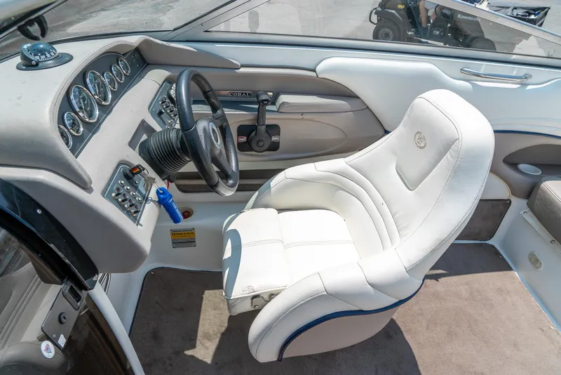 Slide: The Image of Interior of a 2001 Cobalt 227 Cuddy boat, featuring a sleek dashboard and comfortable seating. - 19