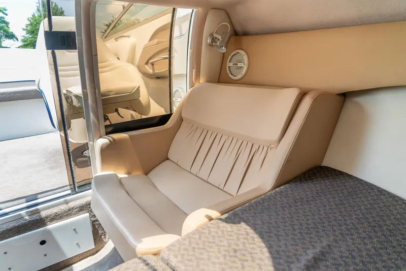 Slide: The Image of Interior of 2001 Cobalt 227 Cuddy boat, featuring beige seating and compact cabin space. - 25