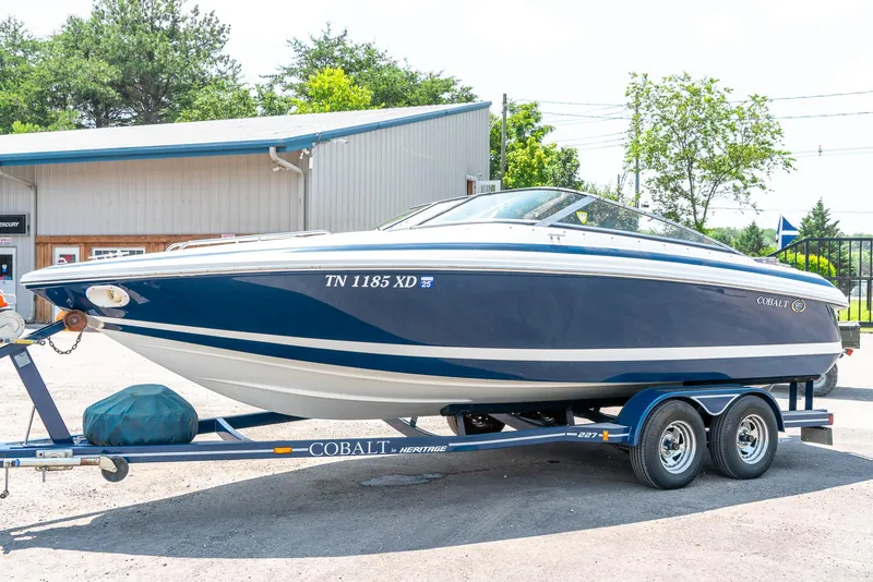 Slide: The Image of 2001 Cobalt 227 Cuddy boat on trailer, parked outdoors near a building. - 4
