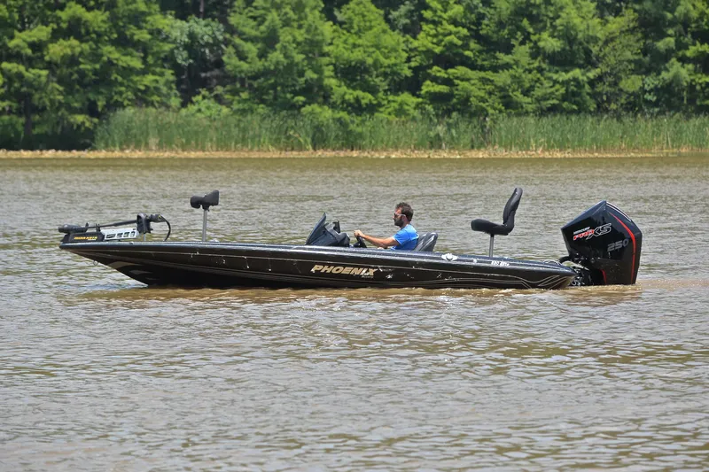 Slide: The Image of 2022 Phoenix 920 Elite boat on a lake with lush green trees in the background. - 10