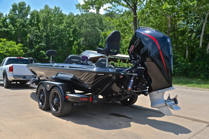 Slide: The Image of 2022 Phoenix 920 Elite boat on trailer, parked outdoors with trees in background. - 13