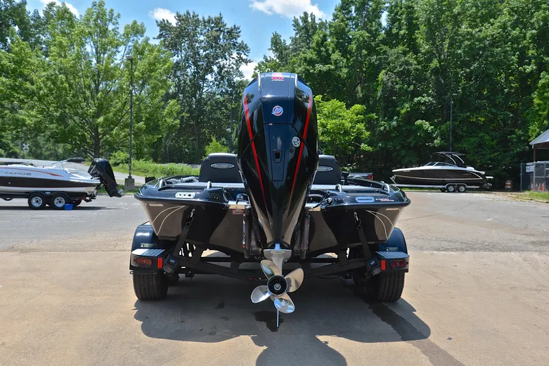 Slide: The Image of 2022 Phoenix 920 Elite boat, rear view, parked outdoors with trees in the background. - 14
