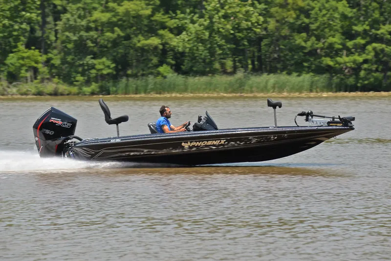 Slide: The Image of 2022 Phoenix 920 Elite boat speeding on a lake with lush green trees in the background. - 3