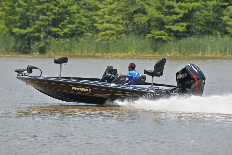 Slide: The Image of 2022 Phoenix 920 Elite boat speeding on a lake with lush green trees in the background. - 4