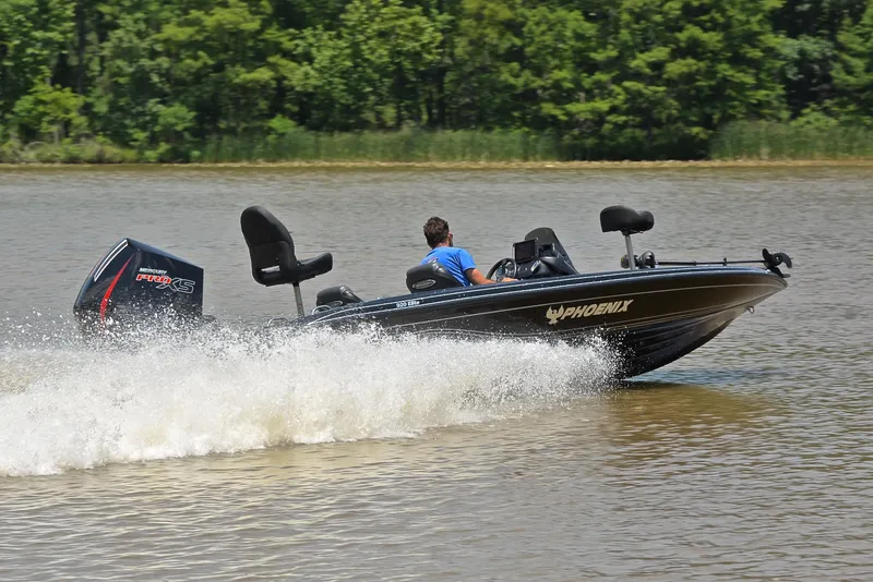 Slide: The Image of 2022 Phoenix 920 Elite boat speeding on a lake with lush green trees in the background. - 5