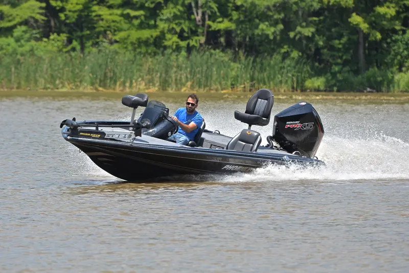 Slide: The Image of Man driving 2022 Phoenix 920 Elite boat on a lake. - 6