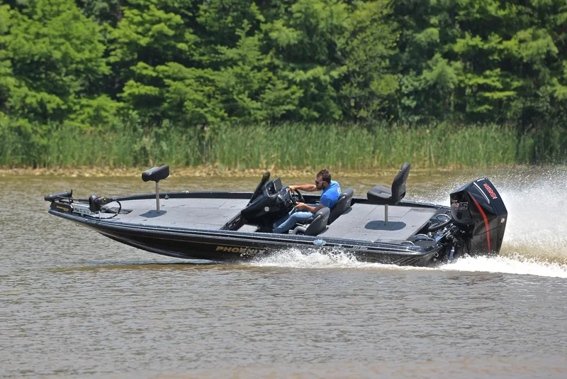 Slide: The Image of 2022 Phoenix 920 Elite boat speeding on a lake with lush green trees in the background. - 8