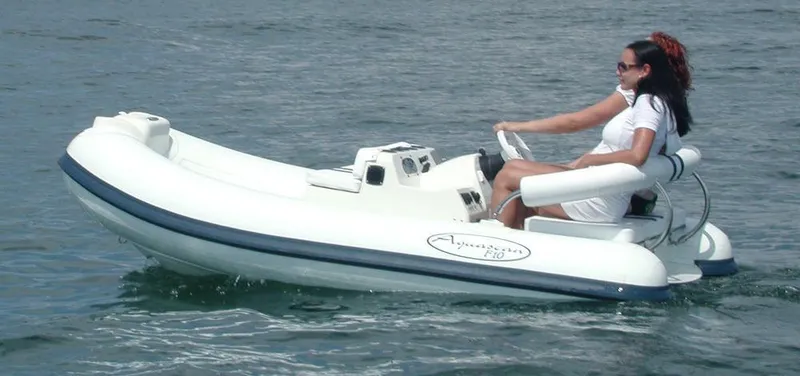 Slide: The Image of Woman driving 2015 Aquascan 11 inflatable boat on water. - 2