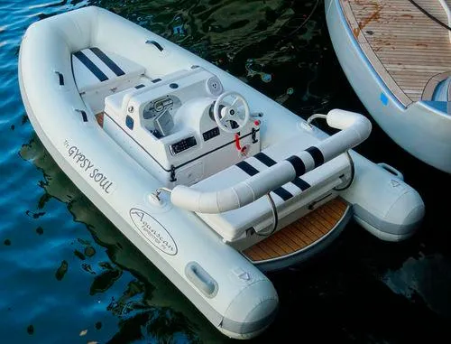 Slide: The Image of Aquascan 11 inflatable boat, 2015 model, docked on water, featuring steering console and seating. - 3