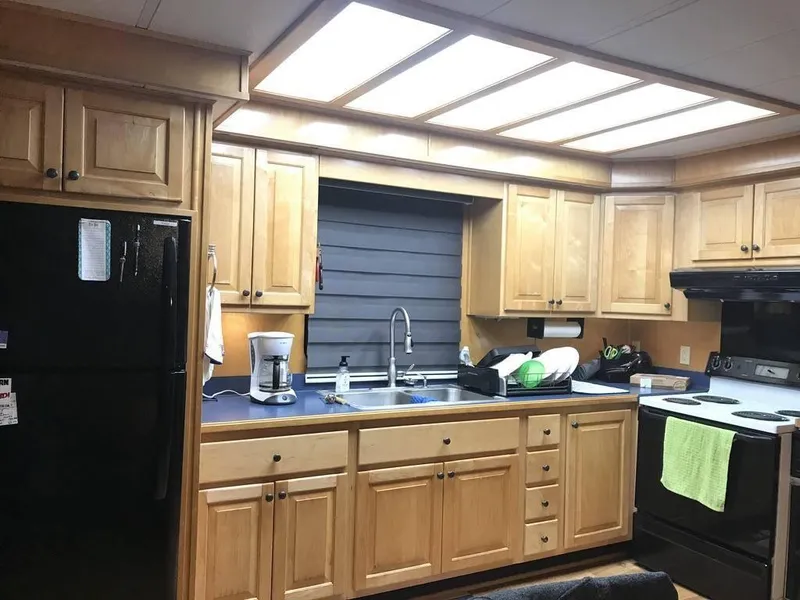 Slide: The Image of Kitchen interior of a 1998 Stardust Cruisers 16x77 houseboat with wooden cabinets and modern appliances. - 10
