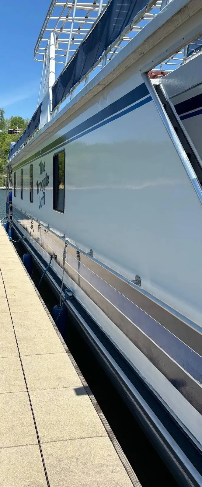 Slide: The Image of 1998 Stardust Cruisers 16x77 houseboat docked, featuring sleek design and modern amenities. - 12