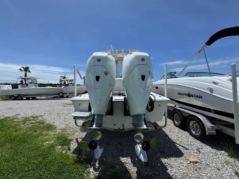 Slide: The Image of Twin outboard motors on a 2021 ZCB 26 Freemason boat, parked on gravel. - 10