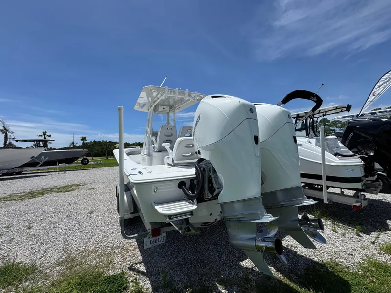 Slide: The Image of ZCB 26 Freemason 2021 boat with dual engines, parked on gravel under clear blue sky. - 11