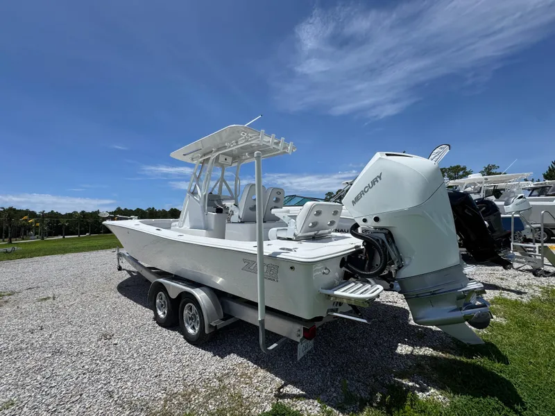 Slide: The Image of 2021 ZCB 26 Freemason boat with Mercury engine on a trailer, parked outdoors. - 12