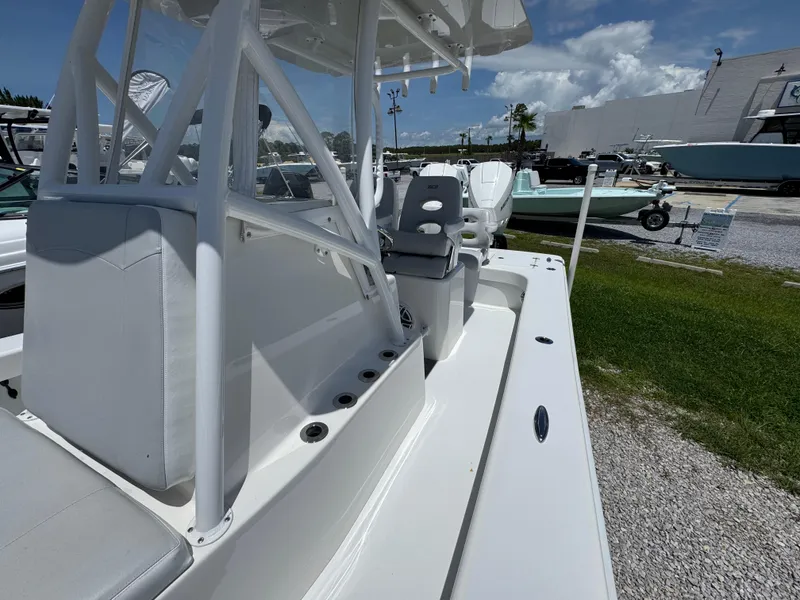 Slide: The Image of 2021 ZCB 26 Freemason boat, white interior, outdoor display, sunny day, grassy and gravel surroundings. - 21
