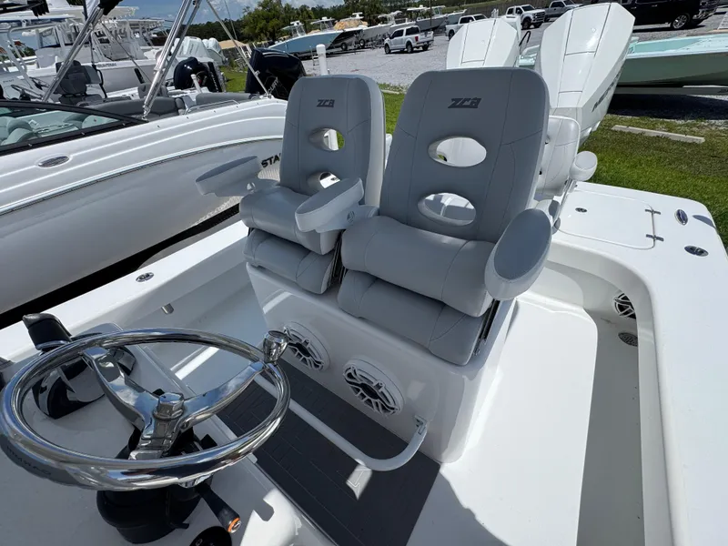 Slide: The Image of 2021 ZCB 26 Freemason boat with dual cushioned seats and steering wheel, docked outdoors. - 23