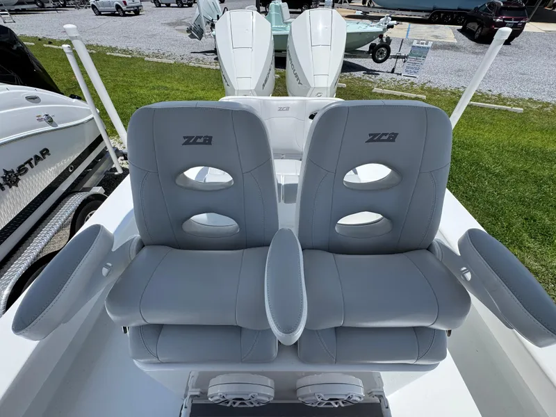 Slide: The Image of 2021 ZCB 26 Freemason boat seats with armrests and speakers, docked outdoors. - 24