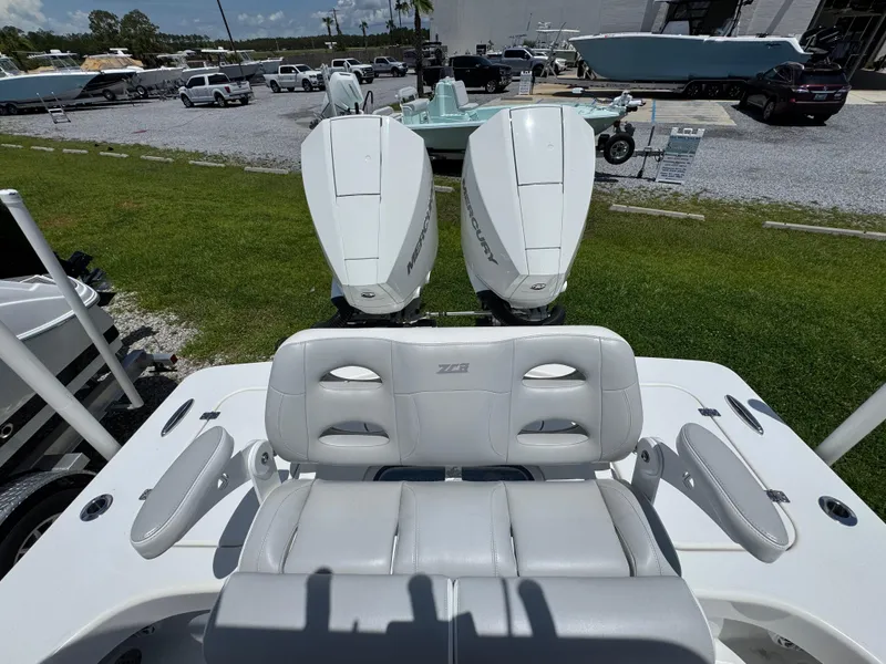 Slide: The Image of ZCB 26 Freemason 2021 boat with dual engines and white seating, parked outdoors. - 32