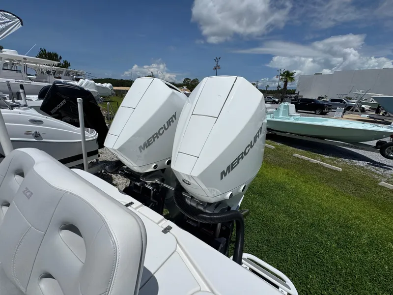 Slide: The Image of Twin Mercury outboard engines on a 2021 ZCB 26 Freemason boat, docked under a clear sky. - 33