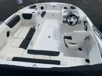 Slide: The Image of 2023 Tahoe 2150 boat interior with white and black seating, steering wheel, and spacious layout. - 4