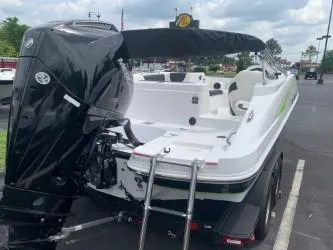Slide: The Image of 2023 Tahoe 2150 boat with outboard motor and ladder, parked outdoors. - 5