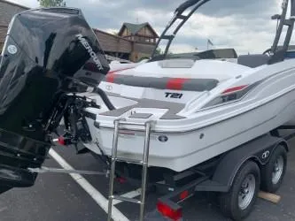 Slide: The Image of 2024 Tahoe T21 boat on trailer with Mercury engine, parked outdoors. - 2