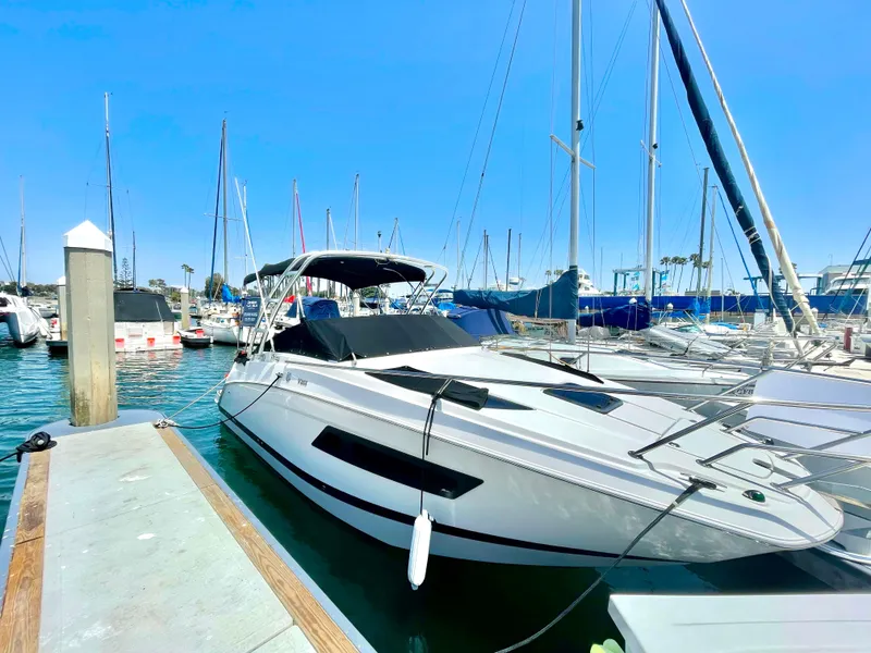 The Image of 2016 Four Winns 255 Vista boat docked in a marina under clear blue skies. - 1