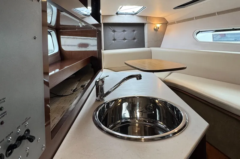 Slide: The Image of Interior of 2016 Four Winns 255 Vista boat with kitchenette and seating area. - 6