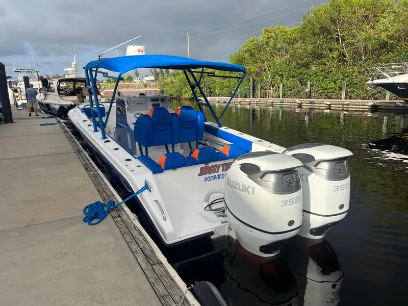 The Image of Spectre 360 Roadster 2011 boat docked, featuring blue canopy and twin Suzuki 350 engines. - 0
