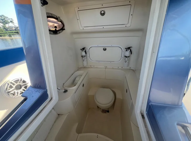Slide: The Image of Interior of 2011 Spectre 360 Roadster boat featuring compact bathroom amenities. - 12