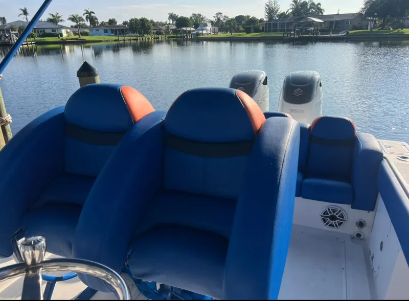 Slide: The Image of Blue and orange seats on a 2011 Spectre 360 Roadster boat by a serene lake. - 14