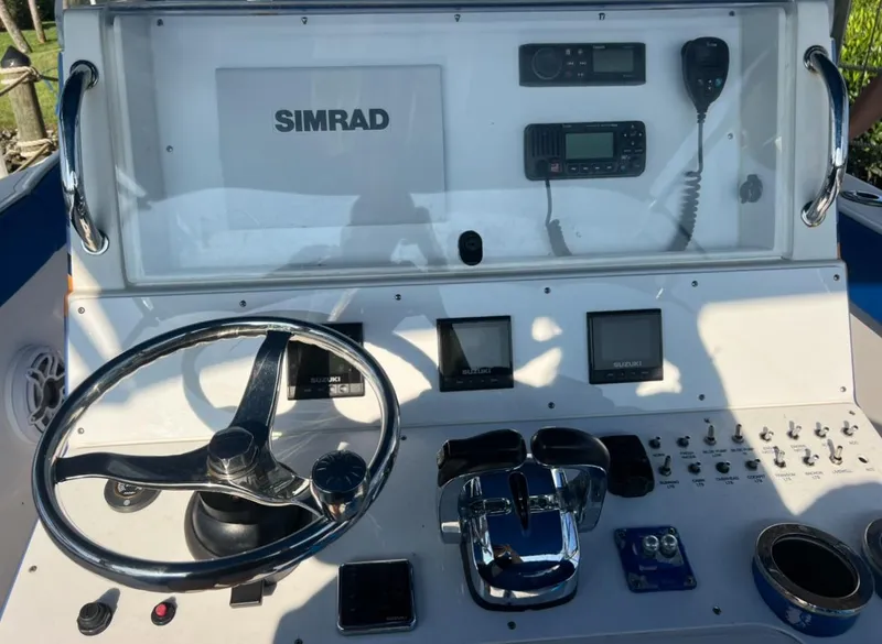 Slide: The Image of Control panel of a 2011 Spectre 360 Roadster boat with steering wheel and navigation equipment. - 15