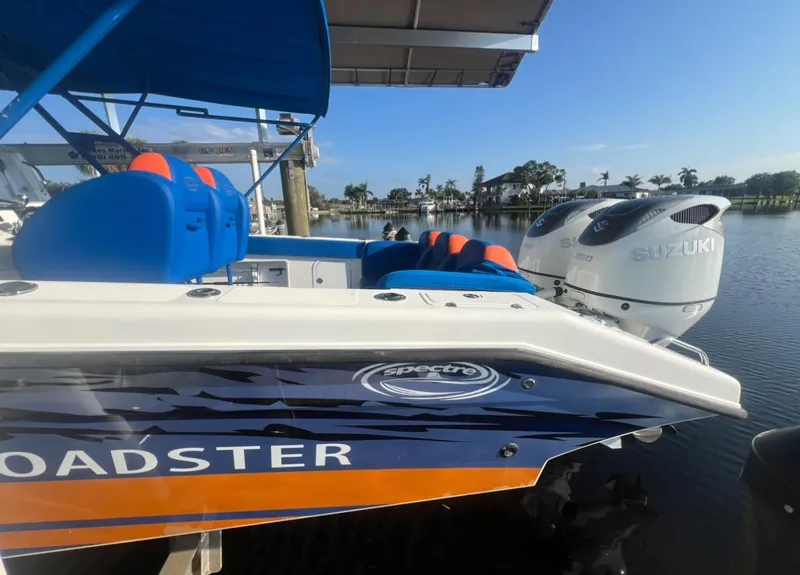 Slide: The Image of Spectre 360 Roadster 2011 boat with Suzuki engines, docked by a scenic waterfront. - 18