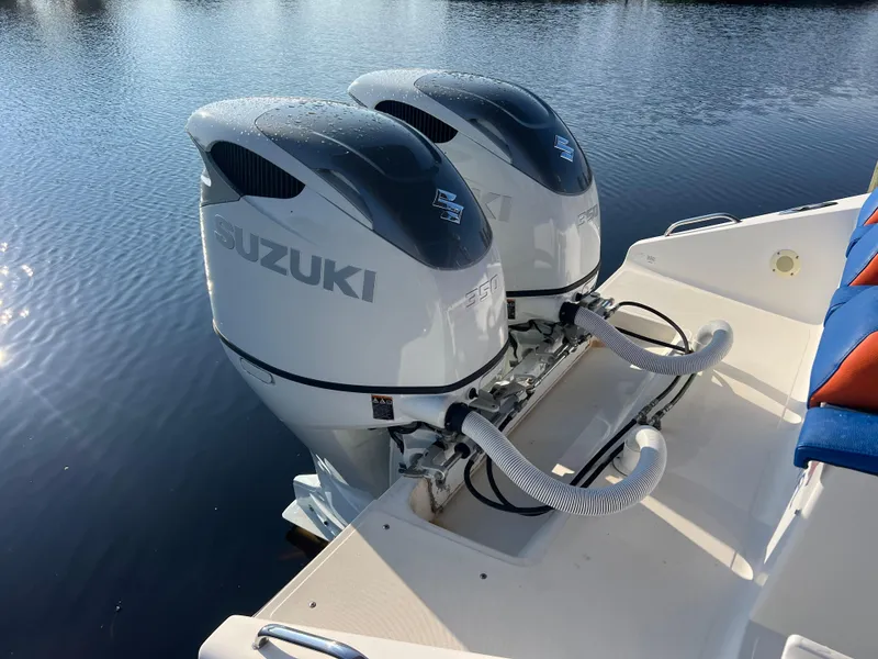 Slide: The Image of Twin Suzuki outboard motors on a Spectre 360 Roadster, 2011 model, docked by the water. - 23