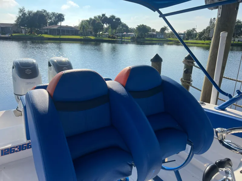 Slide: The Image of Blue seats on a 2011 Spectre 360 Roadster boat by a serene lake. - 28