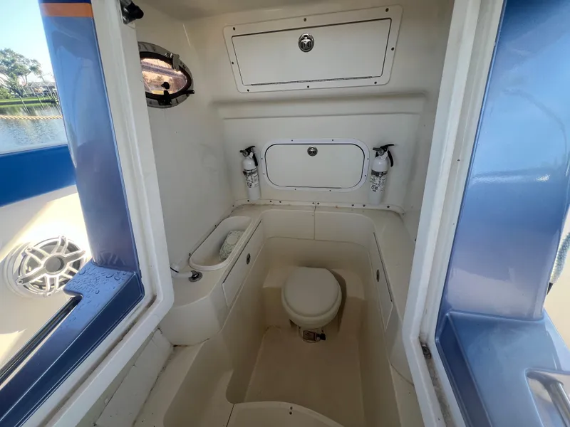 Slide: The Image of Interior of 2011 Spectre 360 Roadster boat with compact bathroom amenities. - 30