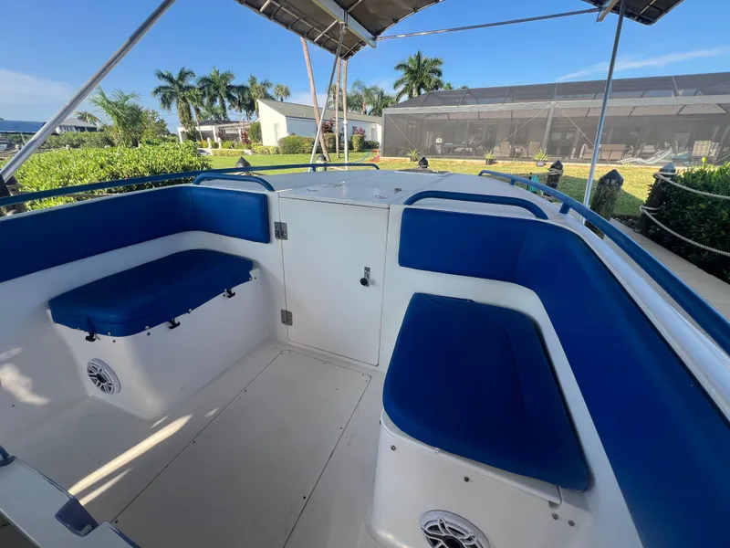 Slide: The Image of Interior of 2011 Spectre 360 Roadster boat with blue seating and canopy. - 32