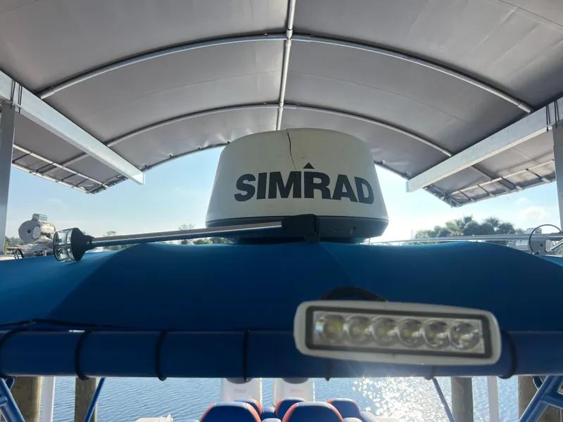 Slide: The Image of Spectre 360 Roadster 2011 with Simrad radar under a canopy by the water. - 39