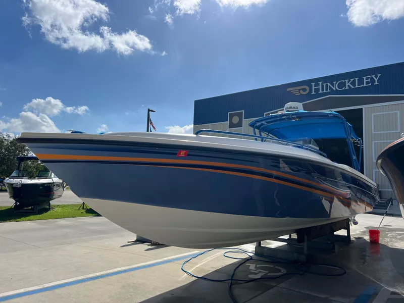 Slide: The Image of 2011 Spectre 360 Roadster boat displayed outdoors at Hinckley facility under blue sky. - 47