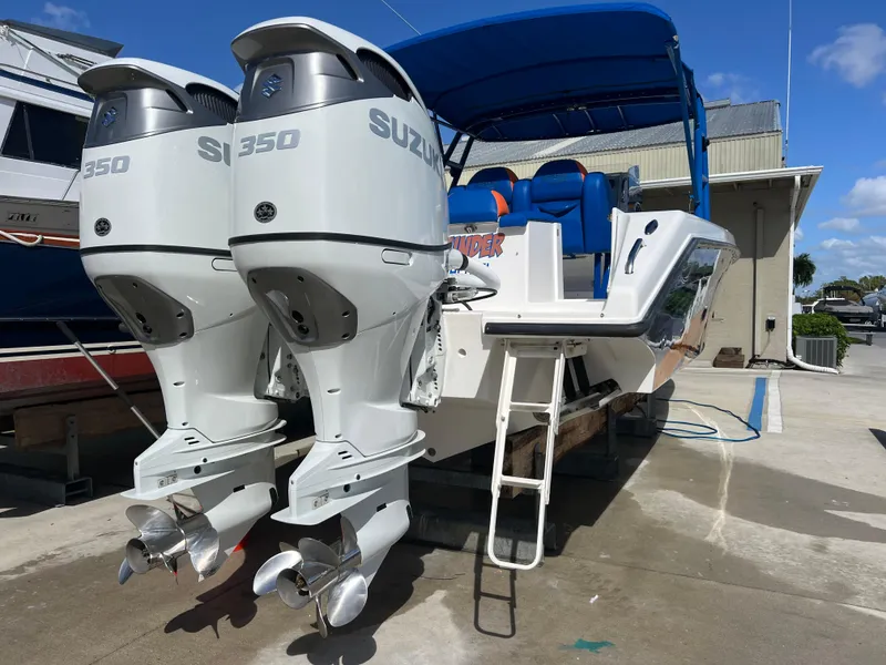 Slide: The Image of 2011 Spectre 360 Roadster boat with twin Suzuki 350 engines, docked under blue canopy. - 48