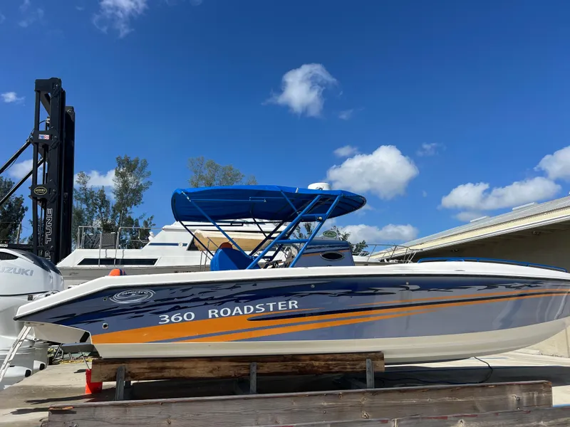Slide: The Image of 2011 Spectre 360 Roadster boat with blue canopy under clear sky. - 49