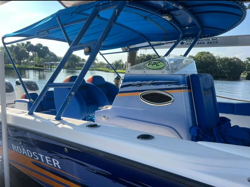 Slide: The Image of Spectre 360 Roadster 2011 boat with blue canopy and sleek design on a sunny day. - 5