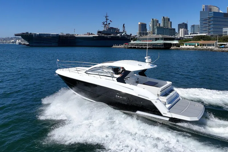 Slide: The Image of 2021 Cruisers Yachts 390 Express Coupe cruising near urban waterfront. - 0