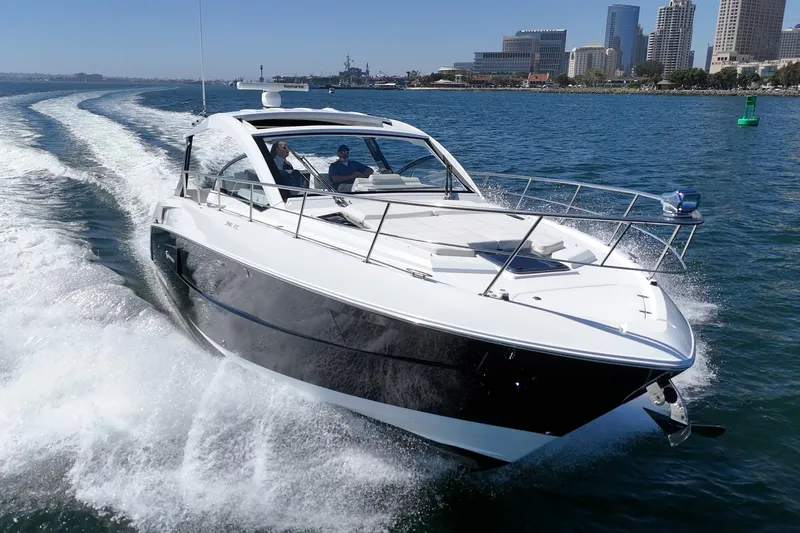 Slide: The Image of 2021 Cruisers Yachts 390 Express Coupe cruising on open water near city skyline. - 15