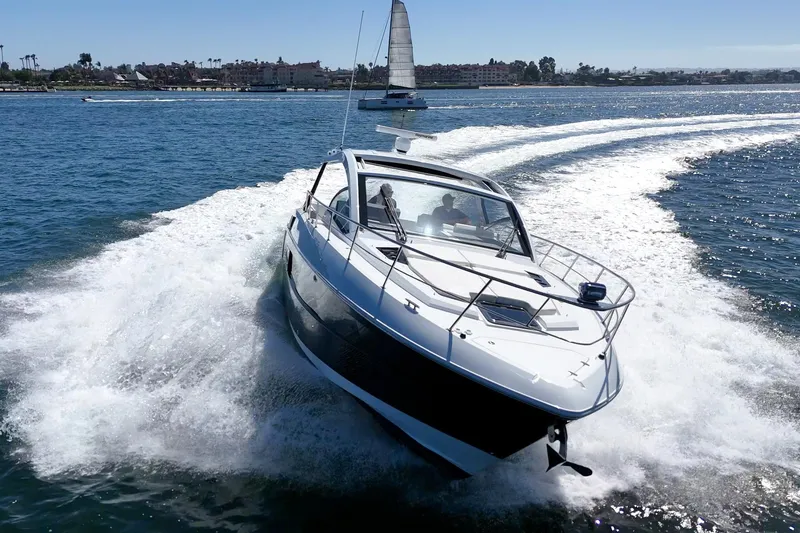 Slide: The Image of 2021 Cruisers Yachts 390 Express Coupe speeding on open water, creating a dynamic wake. - 18