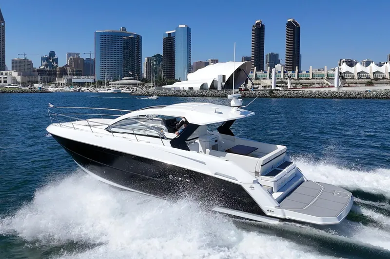 Slide: The Image of 2021 Cruisers Yachts 390 Express Coupe cruising near city skyline. - 19
